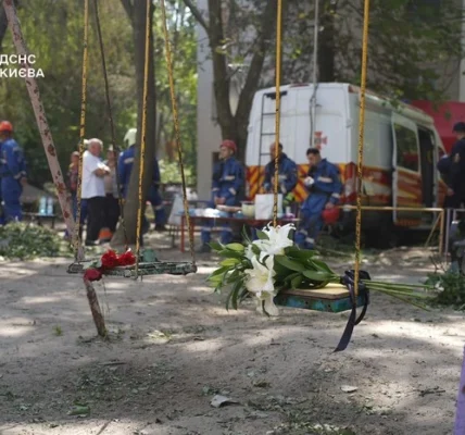 Кияни несуть квіти до знищеного росіянами будинку, де тривають пошукові роботи (фото)