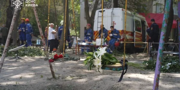 Кияни несуть квіти до знищеного росіянами будинку, де тривають пошукові роботи (фото)